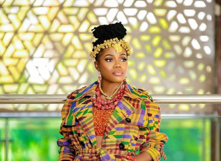 Belinda Nana Ekua Amoah, Mzbel standing wearing an African print